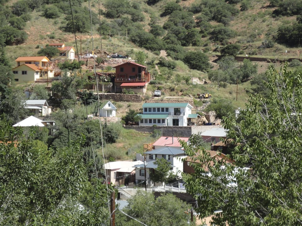 The house is white with green roof with lots of windows to see the views