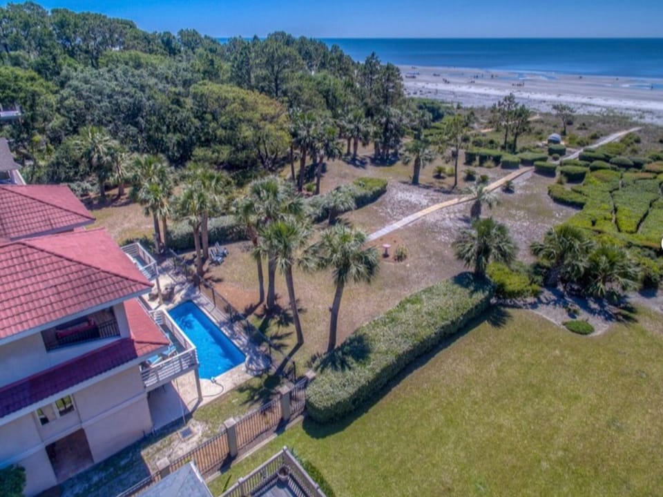 Aerial view of rear of home showing pool and ocean proximity.
