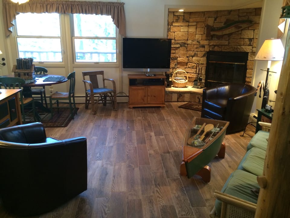 Flat screen TV, wood tile, fireplace.