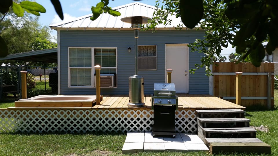 Pet friendly backyard with deck & slab patio with gas grill. 