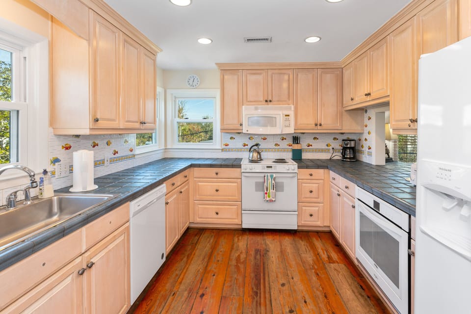 Kitchen has two ovens, and extra large refrigerator and one stove.  