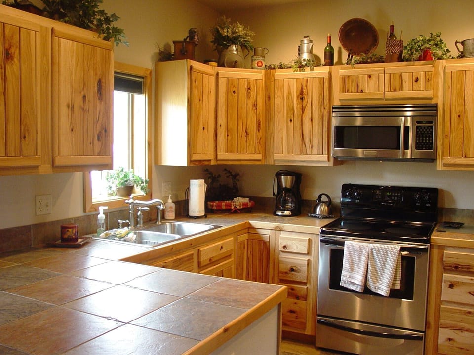Hickory cabinets in well stocked kitchen
