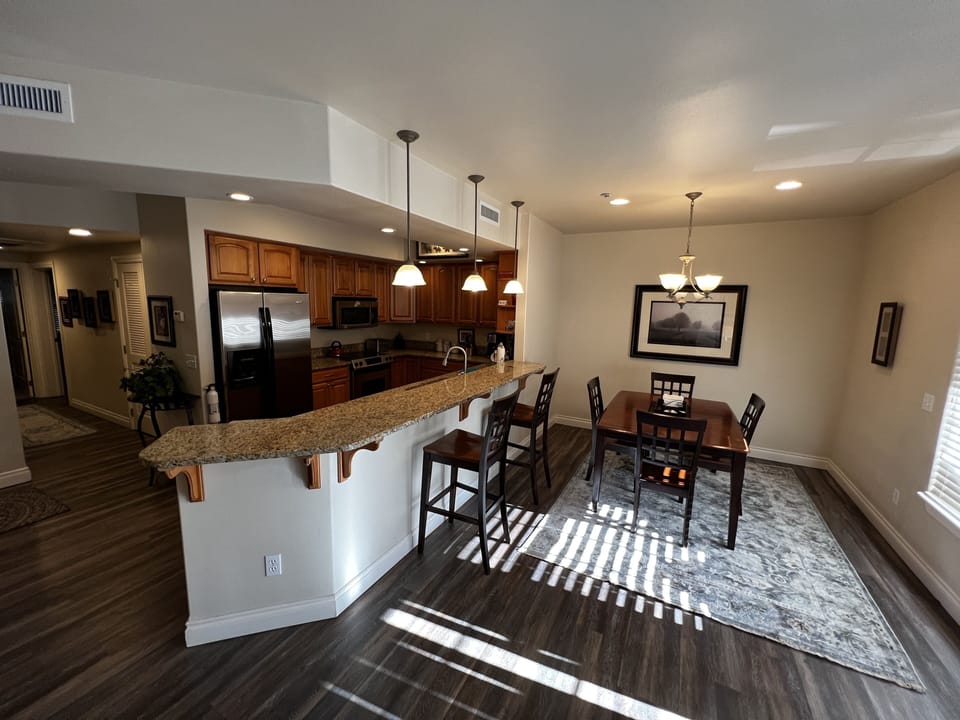 Laminate hardwood floors with area rugs in the living and dining rooms