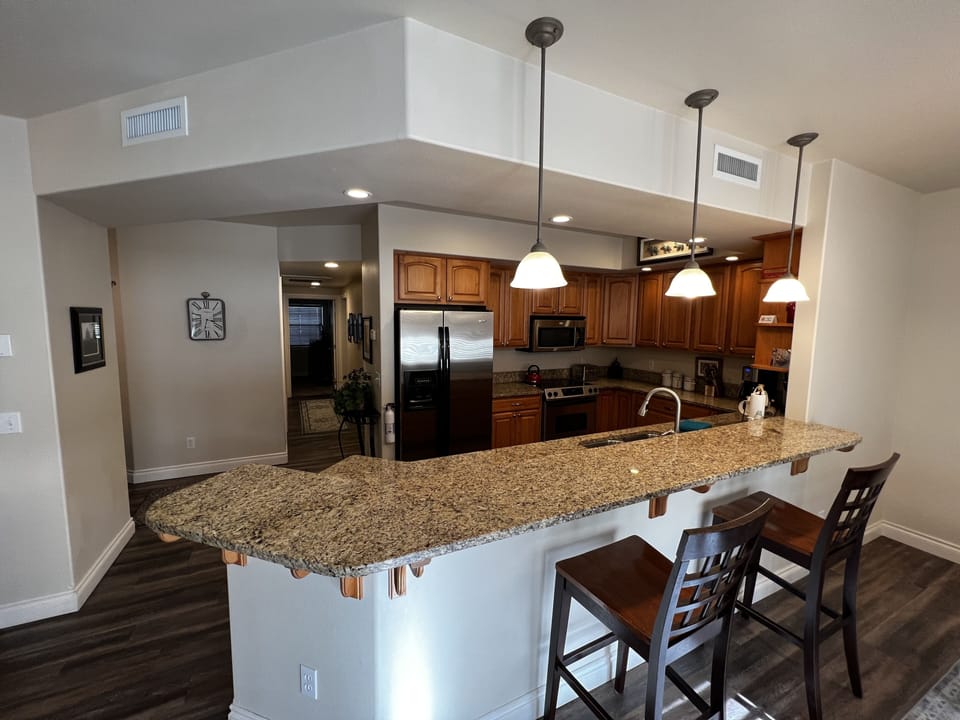 Granite bar in kitchen with two bar chairs
