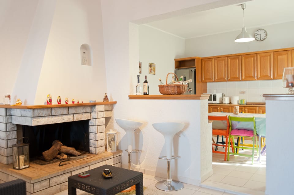 A closer view of the fireplace and bar with colorful kitchen right besides!