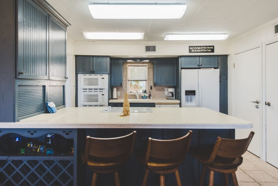 Fully stocked kitchen with 3 barstools.