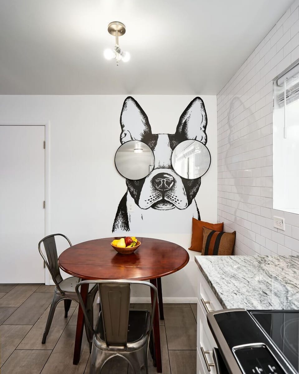 Bright and open kitchen supplied with your basic cooking essentials, stainless steel appliances, breakfast bar seating,  and breakfast nook. Features custom mural Frenchie!