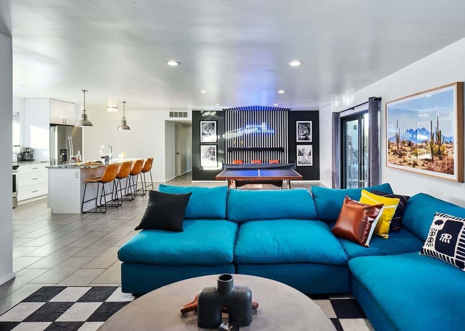 Newly designed living area with designer furnishings, decor, vibrant custom wall paper, and smart TV