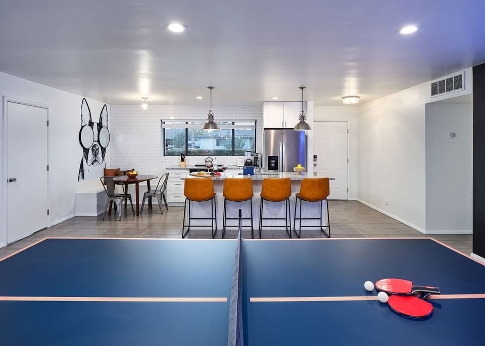 Bright and open concept living space connects game room, living area, and kitchen. Features designer furnishings, and funky decor.