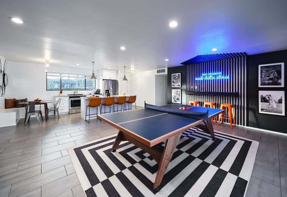 Bright and open concept living space connects game room, living area, and kitchen. Features designer furnishings, and funky decor.