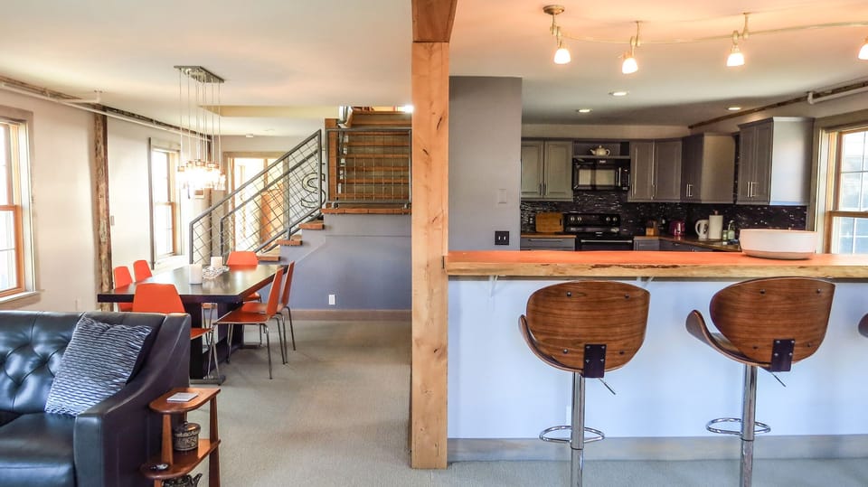 View from the living room into the kitchen and dining room.  Stairs to 2nd floor