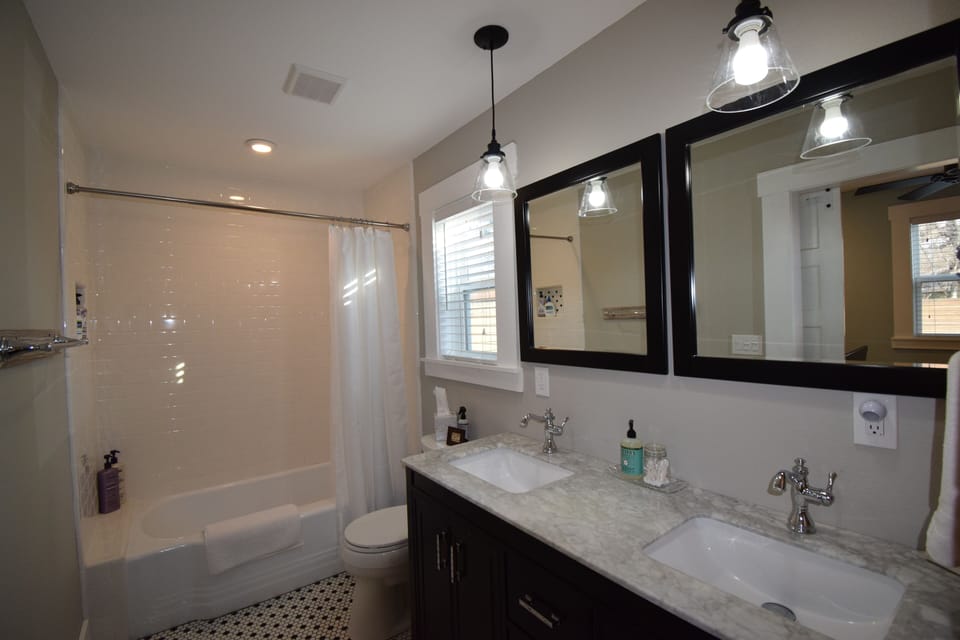 Master Bath: tiled tub/shower comber with refinished original cast iron tub 