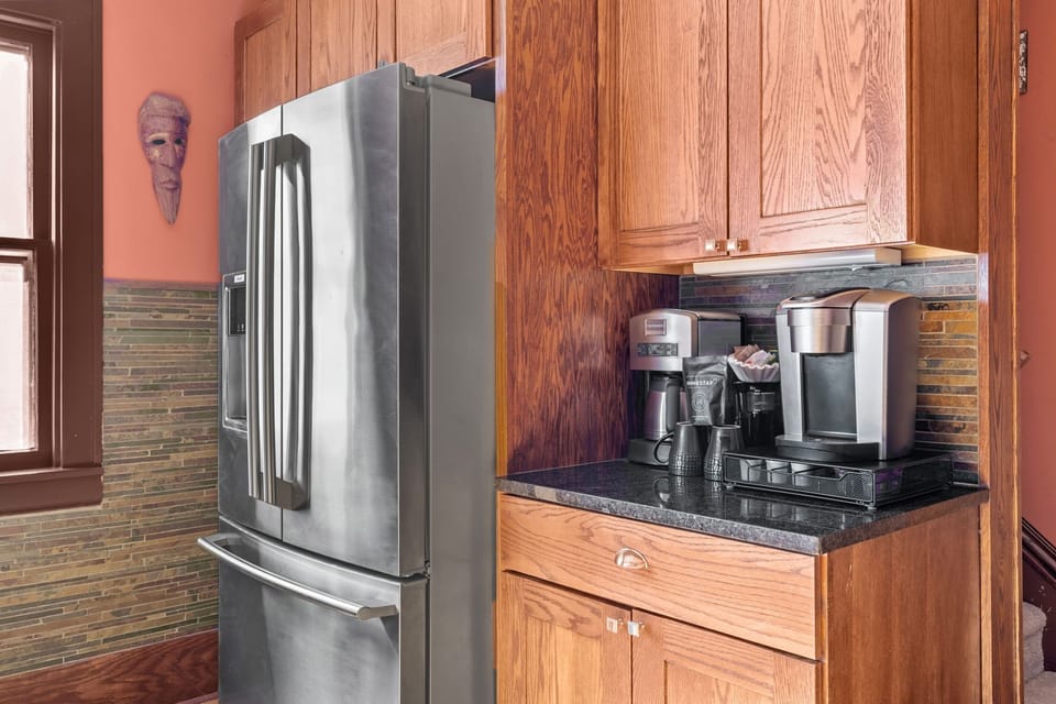 Your kitchen features rich wood cabinetry, granite counters, and modern appliances including a spacious refrigerator and coffee station for perfect mornings.