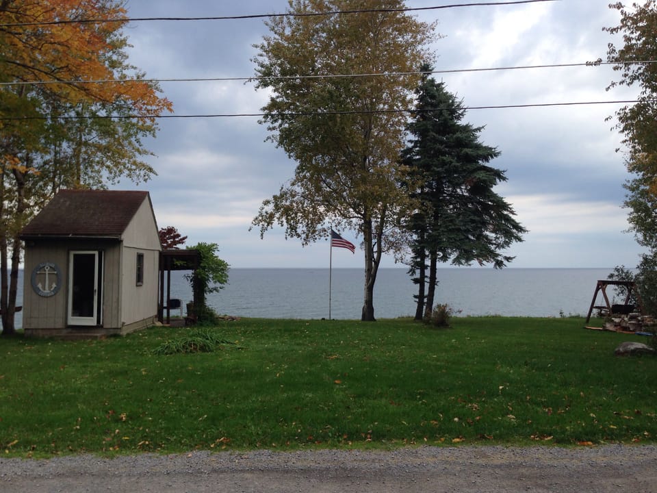 Across the dirt road is the shed and Lake Ontario