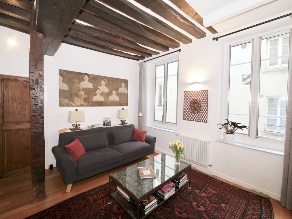 The sitting-room features designer sofa, Persian rugs and various antiques
