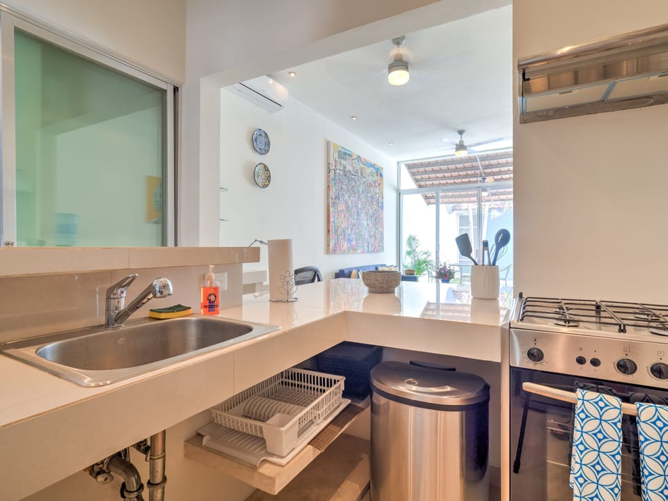 Kitchen stocked with cooking essentials including pots/pans, S&P, olive oil.