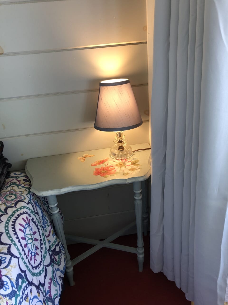 Antique table and lamp in bedroom on porch. 
