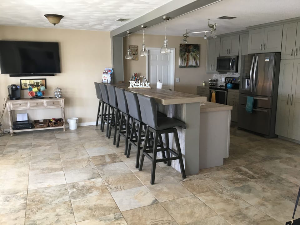 Kitchen with coffee bar and a bar w/seating for 6 and a 55" tv.