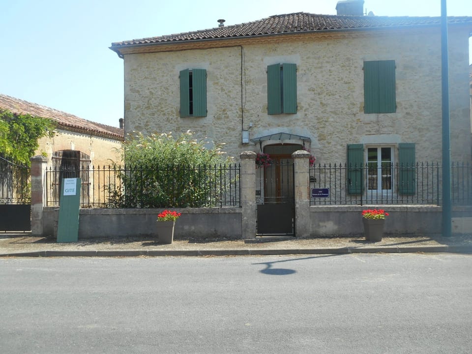 View of front of main house with board indicating the Gite, as directions