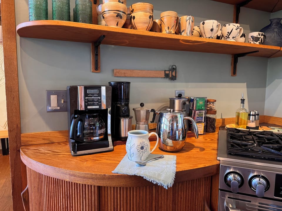 Charming coffee station with artisan mugs and a warm, well-equipped kitchen