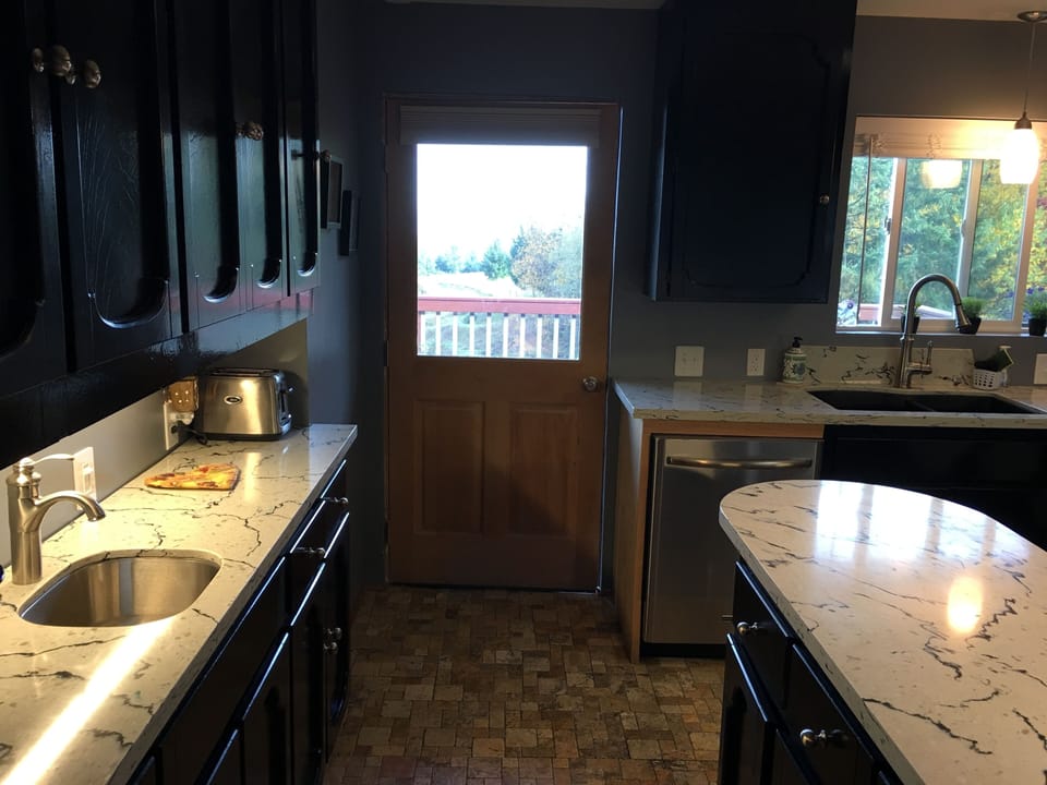 Kitchen door leading to outside deck with gas grill and smoker