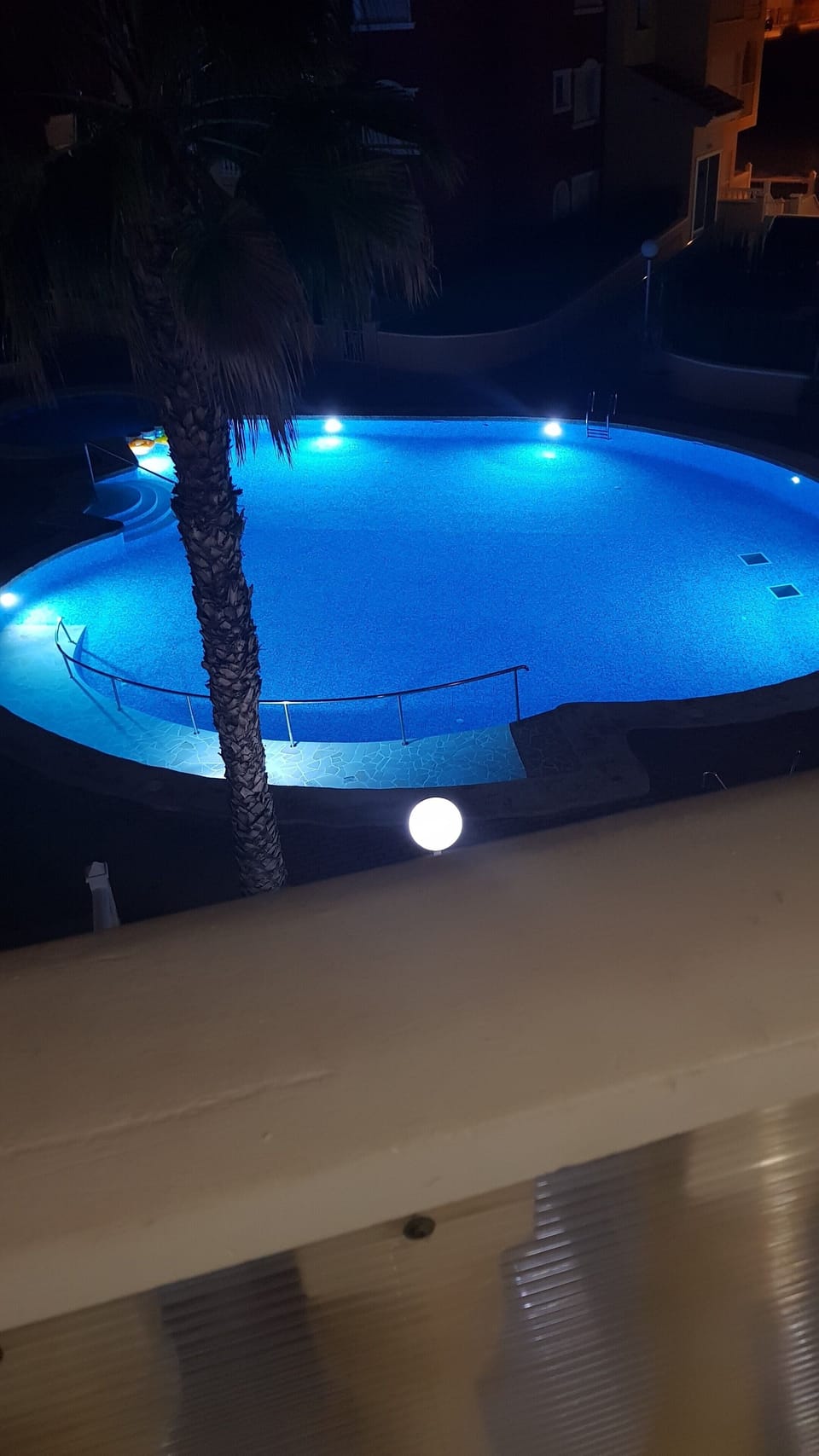 Overlooked pool lit up at night.