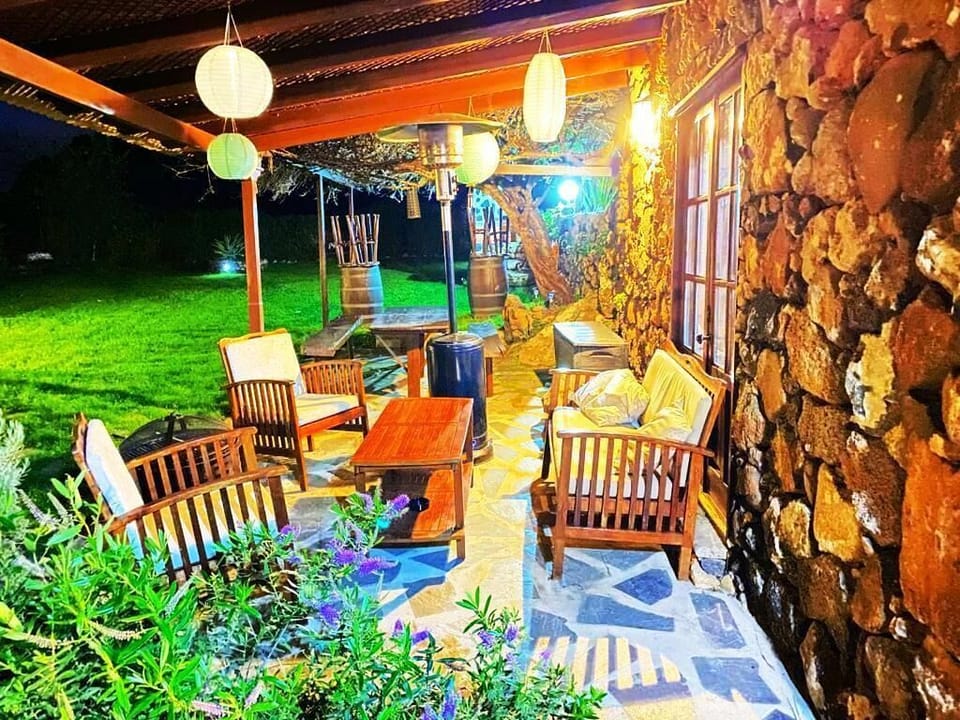 Porche con juego de terraza fogata y estufa exterior bajo pergola en fachada 