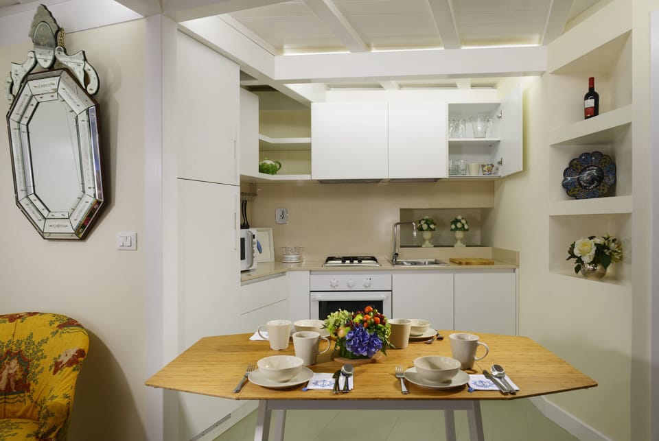 The dining table and the kitchen where you will find all you need.
