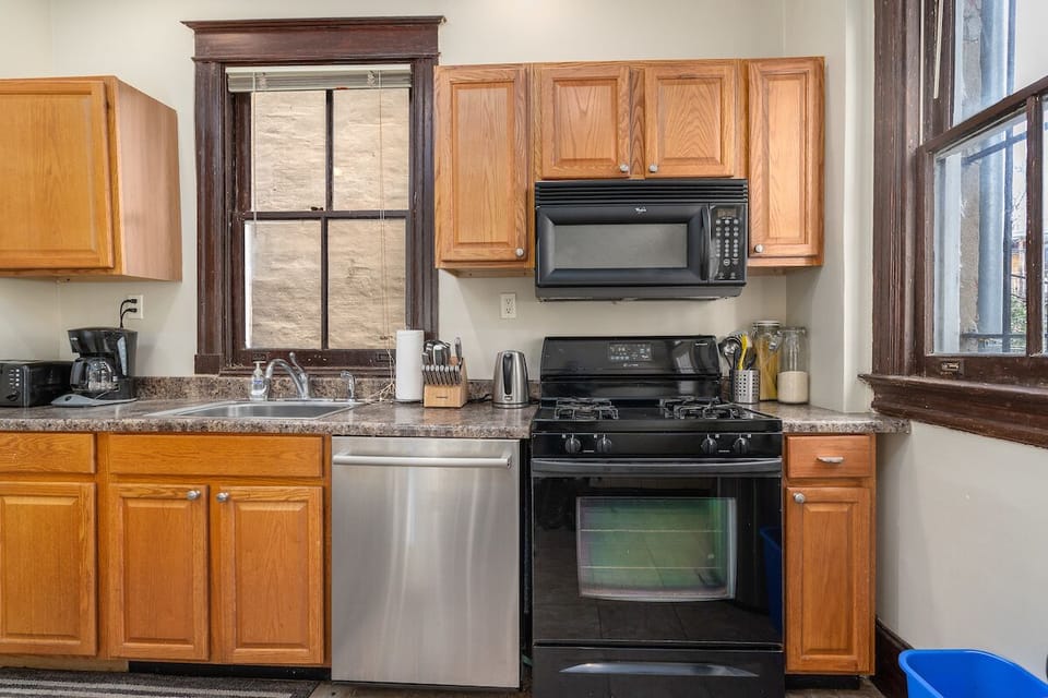 kitchen with dishwasher, sink, oven, and recycling bin