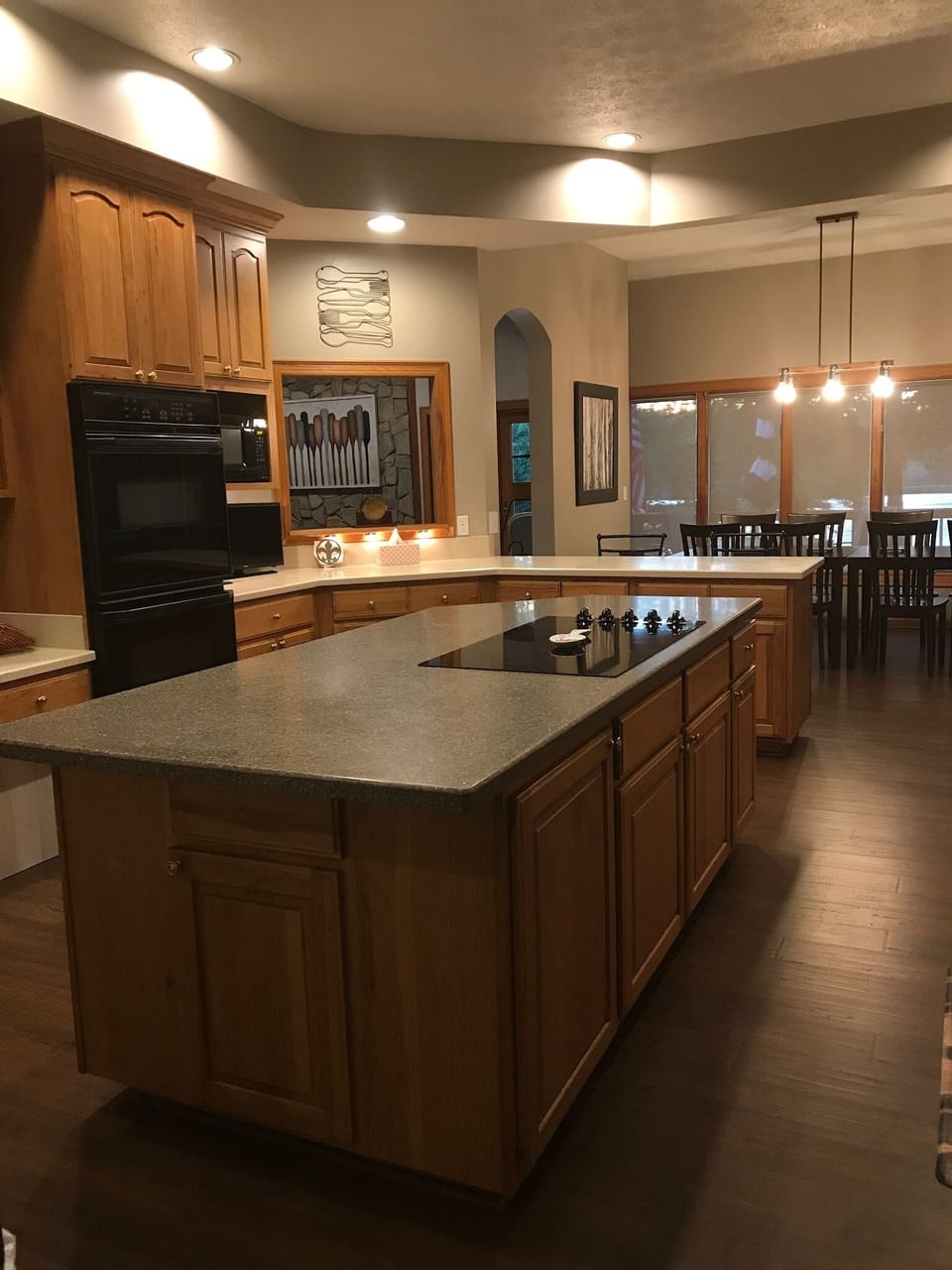 double oven, huge island,  kitchen table, lots of pots, pans, plates, appliances