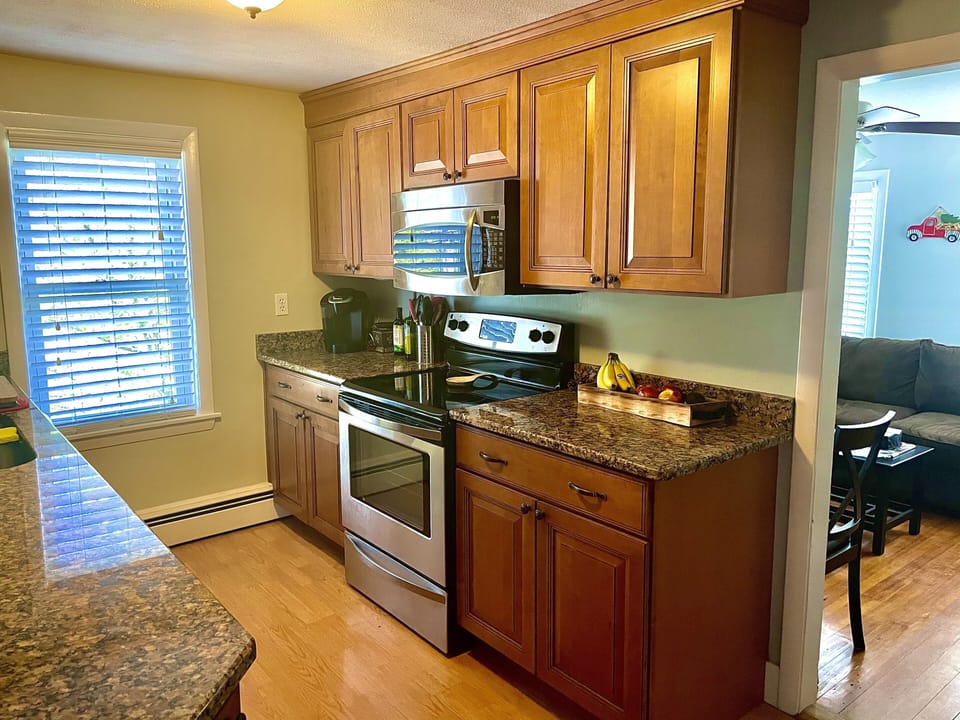 Galley kitchen with granite countertops and stainless appliances