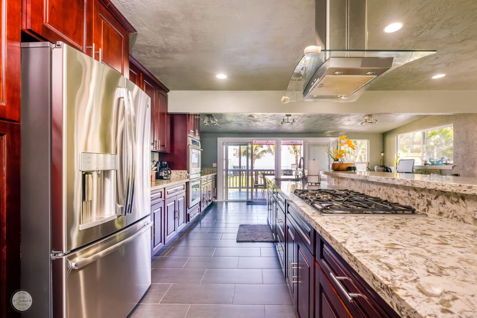 Modern Kitchen features gas range stove, double oven and 15ft quartz island.