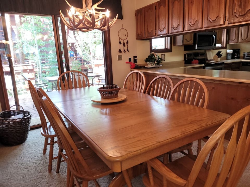 Dining area with seating for 8 at the table and 2 more seats at the breakfast bar