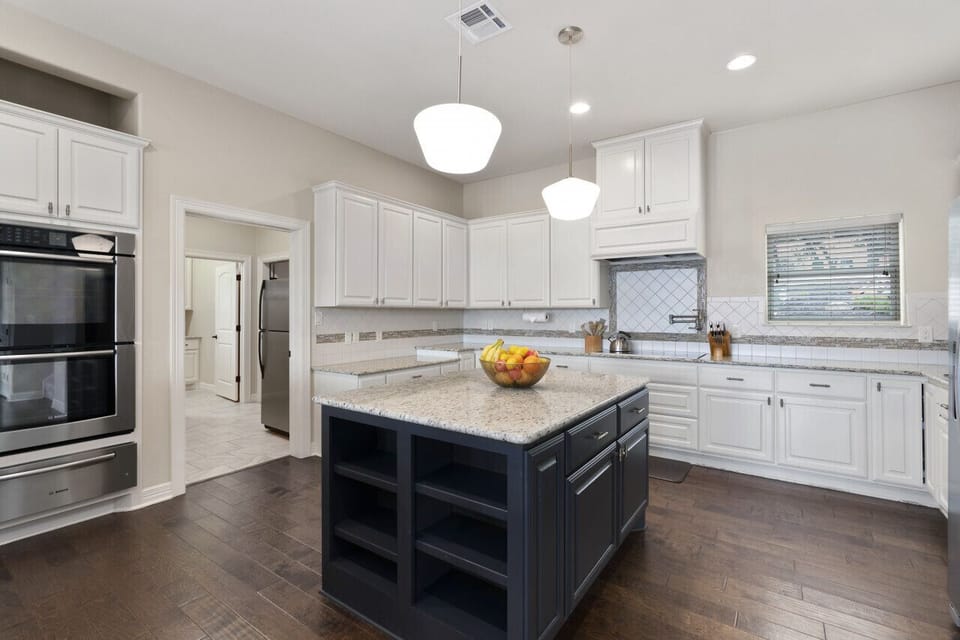 Double Ovens, Large Hood for stove, and multiple coffee machines this kitchen