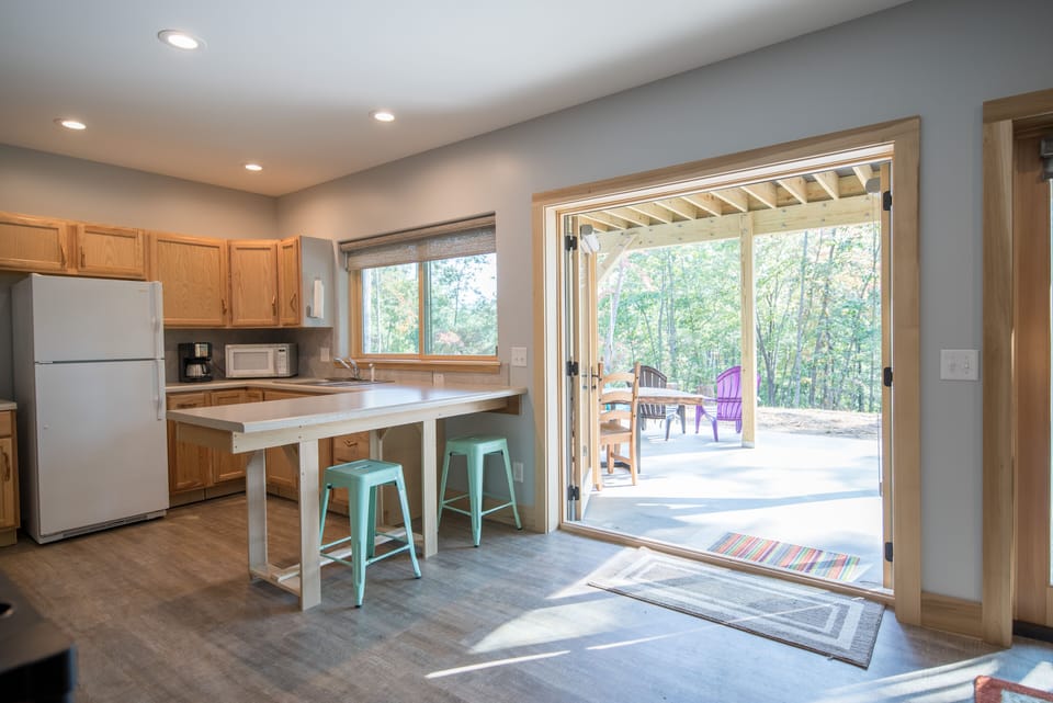 Basement bar and kitchen space with French doors to outside patio.