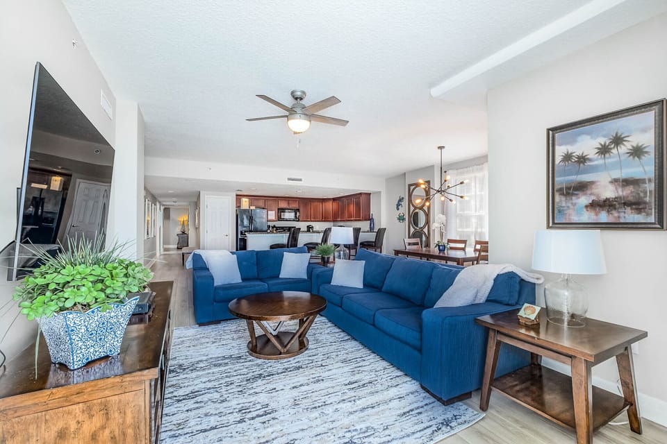 Living room with sofa and loveseat, wall mounted 65" 4k smart tv. 