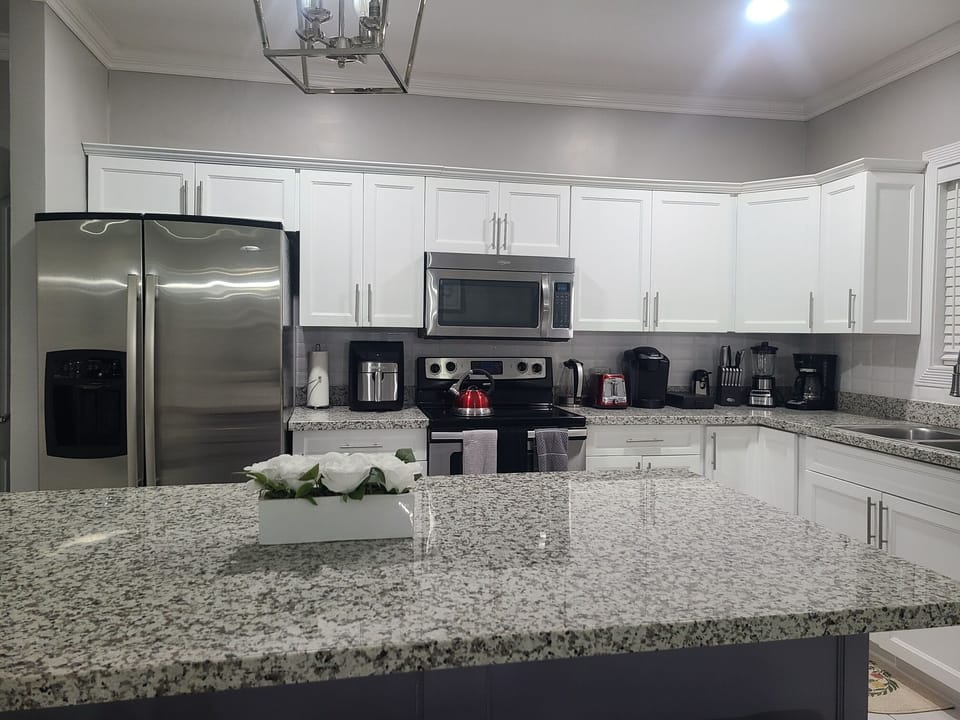Modern kitchen with appliances including air fryer and coffee maker. 