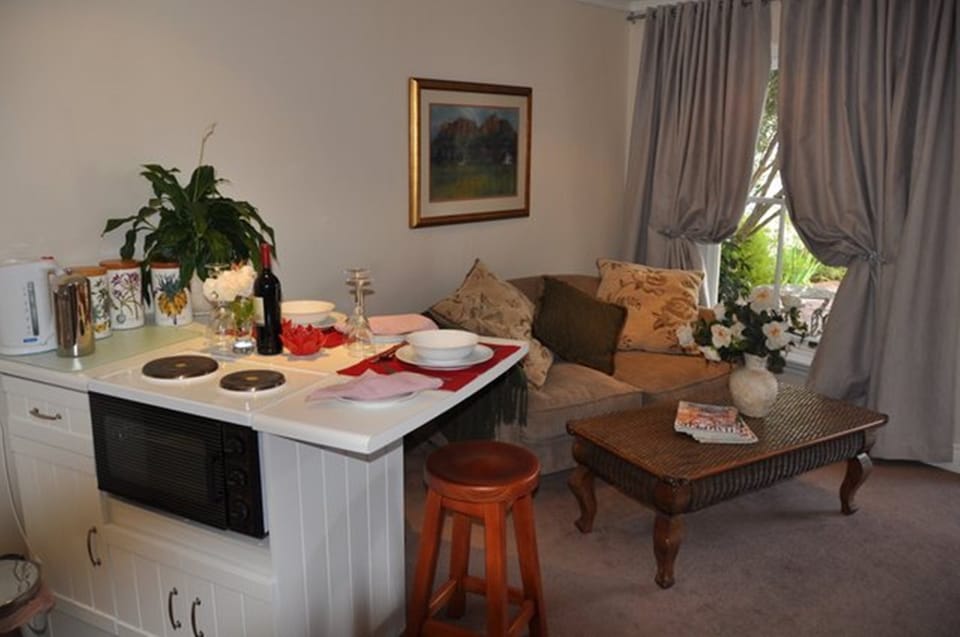  Cottage kitchen/dining looking onto lounge. Hot place and oven. Utensils etc.