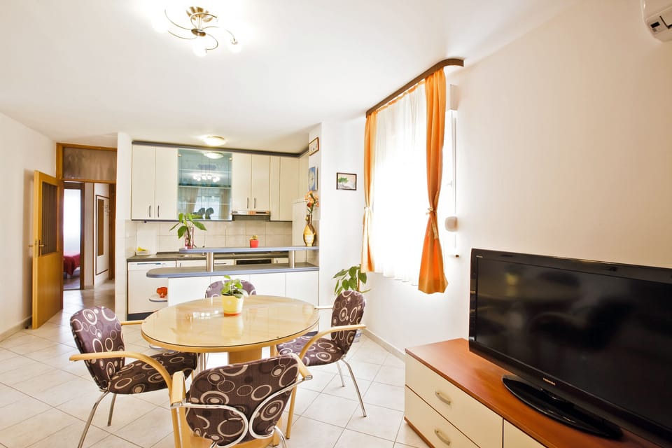 Living area with tv set and fully equipped kitchen with dishwasher  