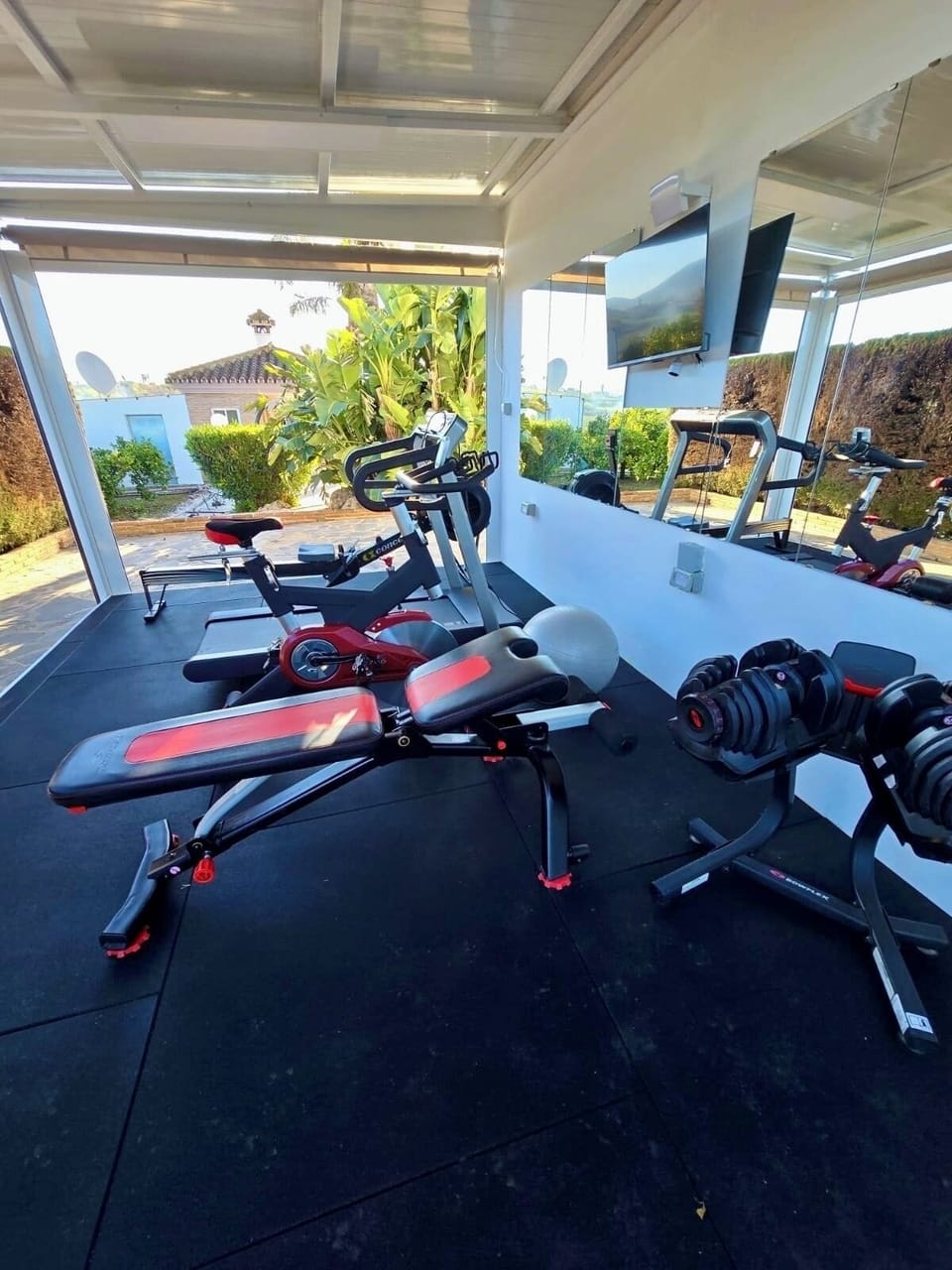 Outdoor covered gym w/ rower, bike, treadmill, bench + 2 x adjustable dumbbells