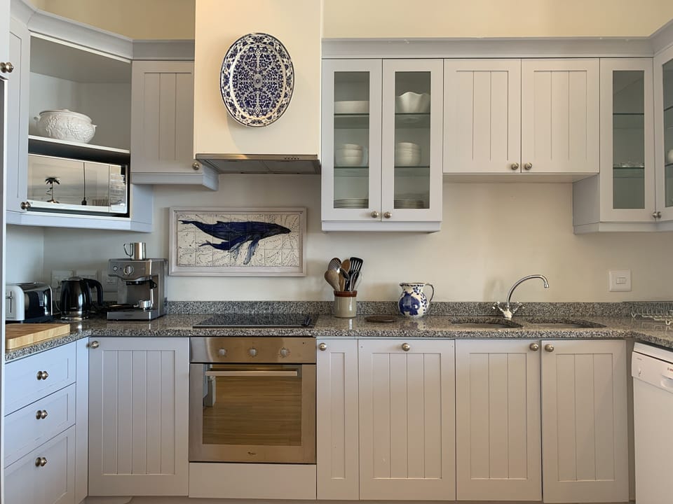 Spacious kitchen with an electric oven and hob, dishwasher and washing machine.