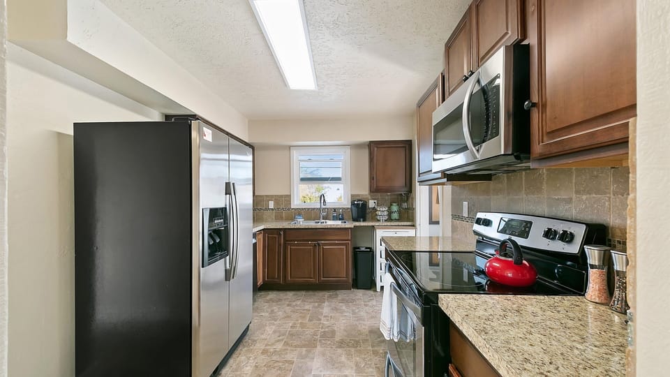 Full kitchen with full size microwave and electric glass stovetop. 
