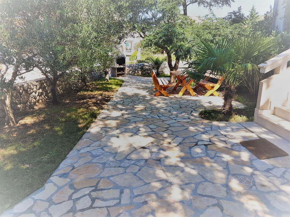 Apartments-Vrtlici-garden with fireplace and wooden table with chairs