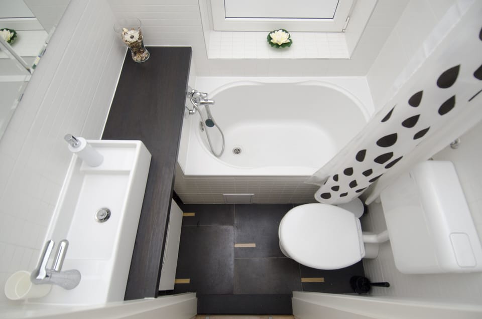 Small but functional bathroom with a bath tab