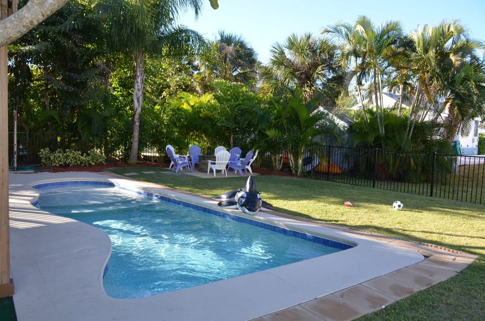 Pool, fire pit, palm trees looking west across street to beach, Gulf + trolley