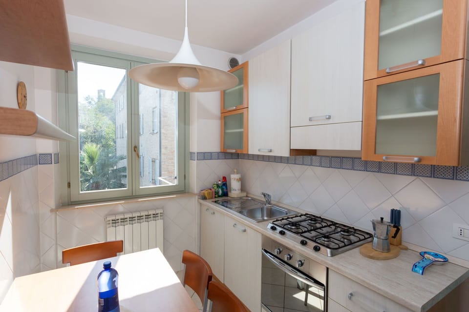 The kitchen with a table for 4 people, a 4 ring hob, oven and a dishwasher
