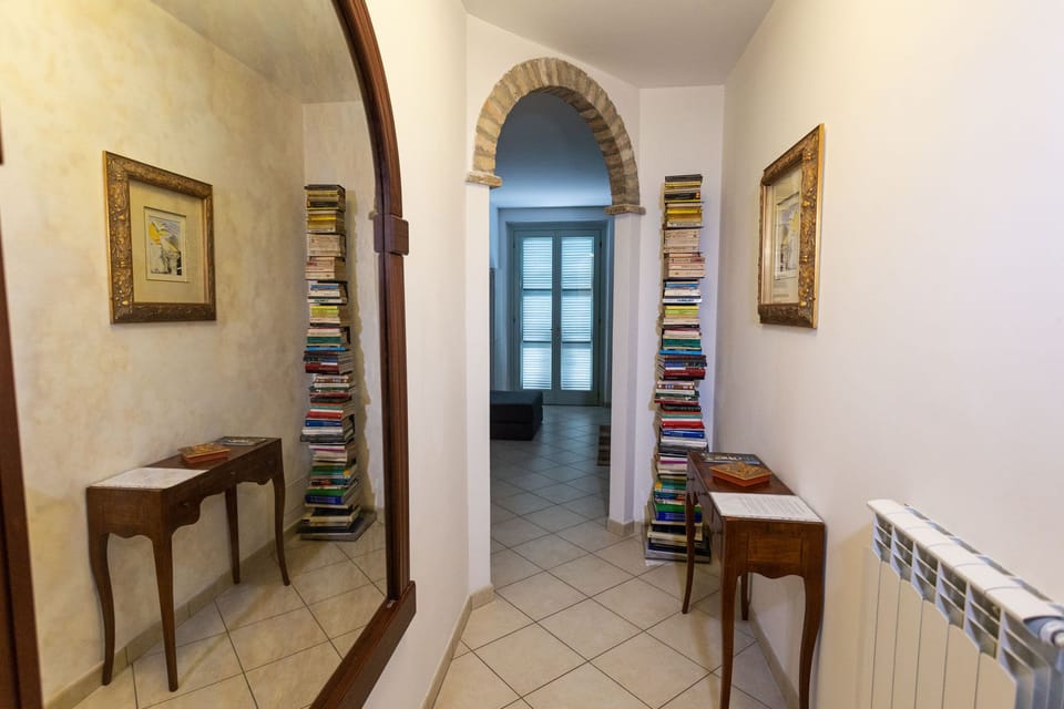 Entrance to the flat with bookcase, consolle and large antique mirror