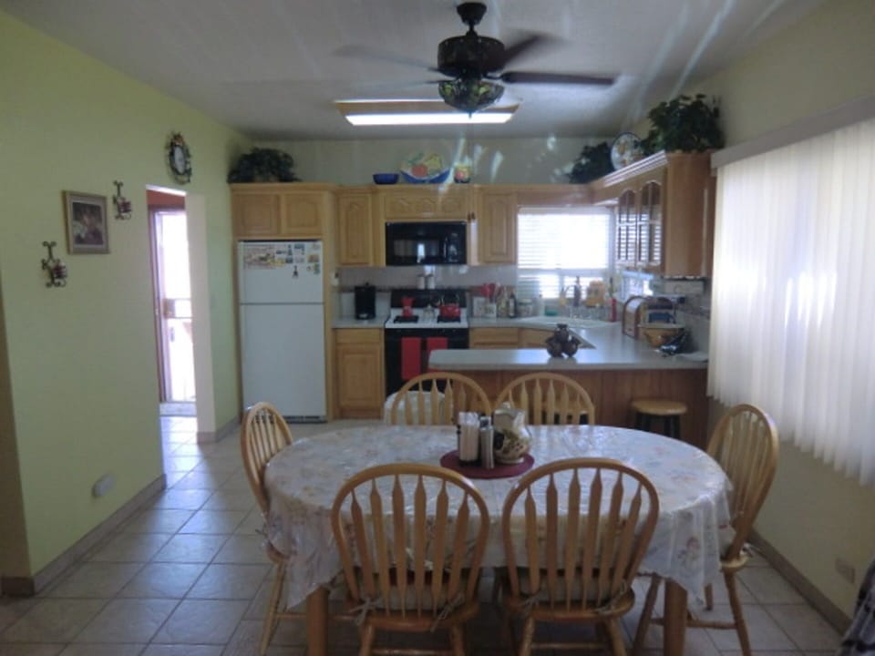 Kitchen table of six and three bar stools at kitchen counter.