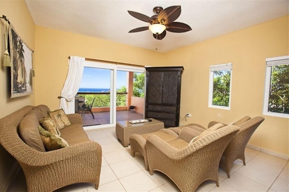 Resin wicker furniture in the main room with view of the turquoise Caribbean reef
