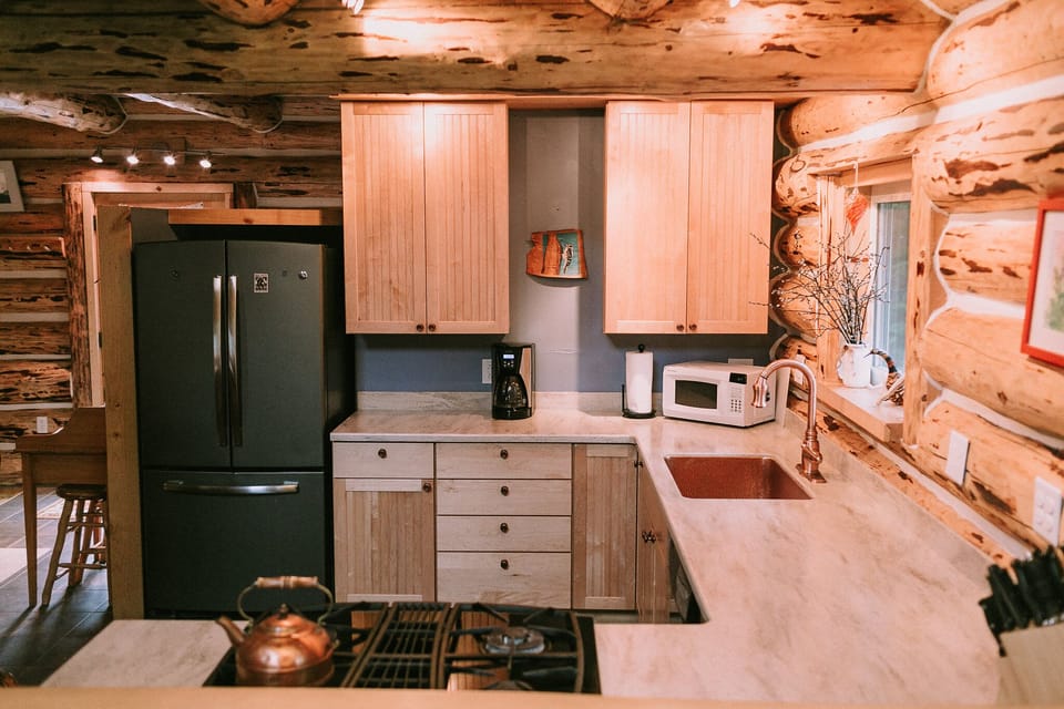 Kitchen: maple cabinets, copper accents, plenty of cook ware and dishes.